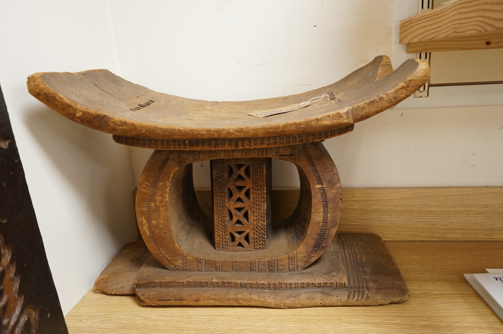 An Ashanti carved wood stool together with a similar headrest, tallest 41cm